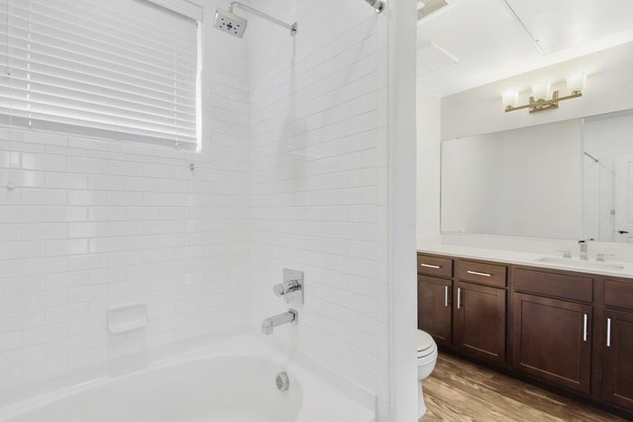 Spacious bathroom with ample storage, a shower/tub combo, and large countertops at Lantower Ambrosio Apartments