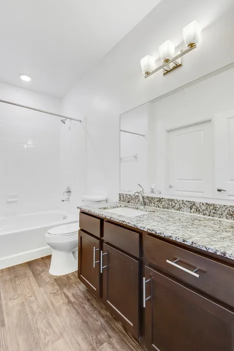 Spacious bathroom with ample storage, a shower/tub combo, and large glossy countertops at Lantower Ambrosio Apartments