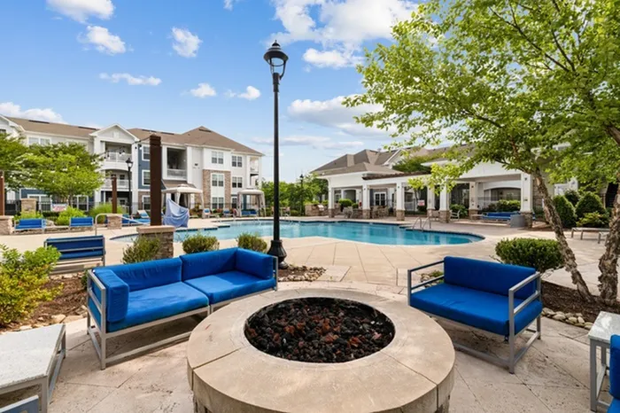 Fire pit lounge with outdoor sofas and side tables at Patterson Place Apartments.