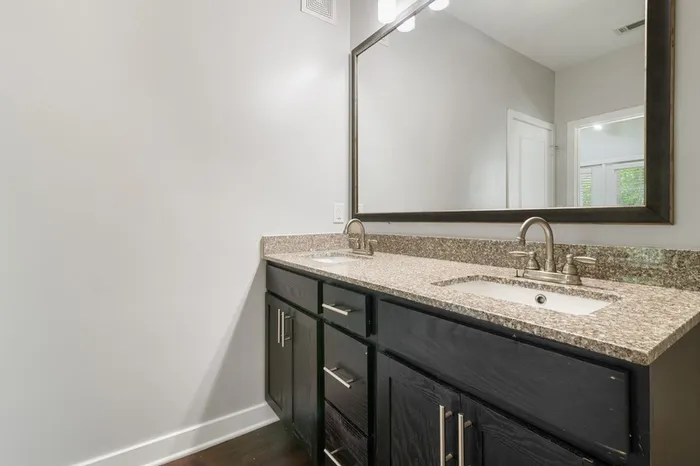 Bathroom with granite countertops and dark-colored cabinetry at Realm at Patterson Place.