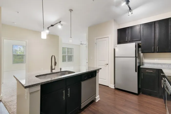 Energy-efficient kitchen with granite countertops, stainless steel appliances, and a kitchen island at Realm at Patterson Place.