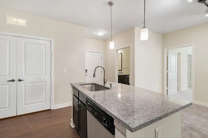 Energy-efficient kitchen with granite countertops, stainless steel appliances, and a kitchen island at Realm at Patterson Place.