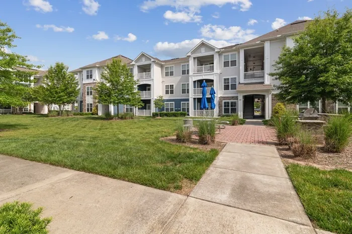 Front of Realm at Patterson Place with trees, walk ways, and picnic benches.