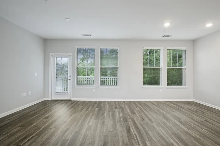 Living room with four large windows and a glass door accessing a balcony at Lantower Garrison Park.
