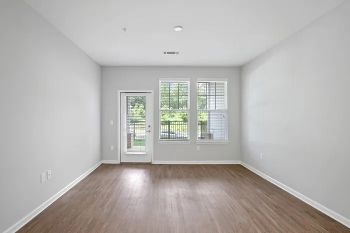 Living room with two large windows and a glass door accessing the balcony at Lantower Garrison Park.