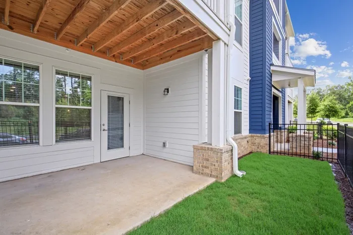 Backyard of an apartment with a covered patio and grassy area at Lantower Garrison Park.