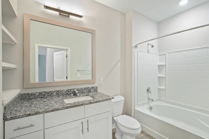 Bathroom at Lantower Garrison park with natural sunlight, granite countertops, and wood-style flooring.