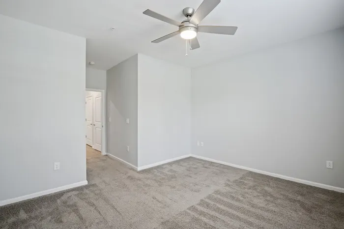 Carpeted bedroom at Lantower Garrison Park  with a ceiling fan.