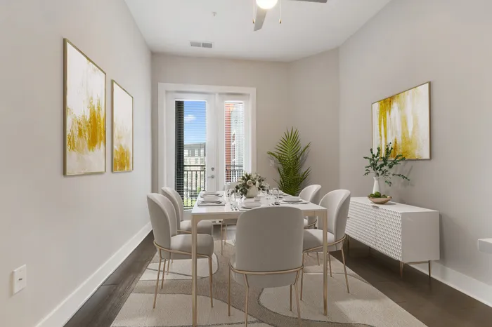 Dining room with private balcony access, wood-style flooring, a modern, cream dining table and yellow wall art at Bullhouse.