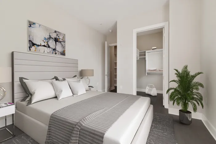 Bedroom with wood-style flooring, 10-foot ceilings, an expansive walk-in closet, a large floor-to-ceiling window with ample natural sunlight and a modern, grey and cream bed at Lantower Bullhouse.