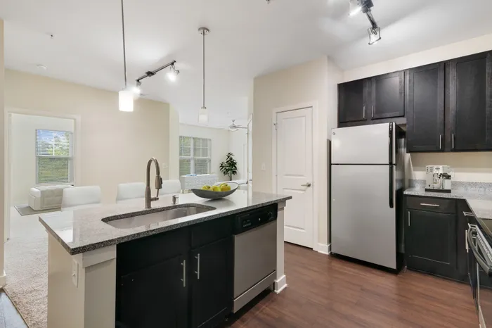 Energy-efficient kitchen with stainless steel appliances, a kitchen island and modern, white furniture at Realm at Patterson Place.