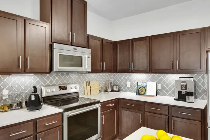 Modern kitchen fit with stainless steel appliances and wood style cabinets at Lantower Ambrosio. Modern kitchen fit with stainless steel appliances and wood style cabinets at Lantower Ambrosio.