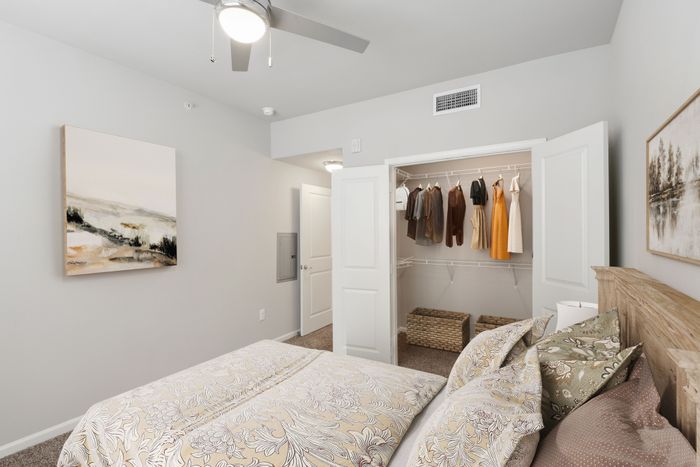 Carpet bedroom with a spacious closet, and a ceiling fan at Lantower Edgewater