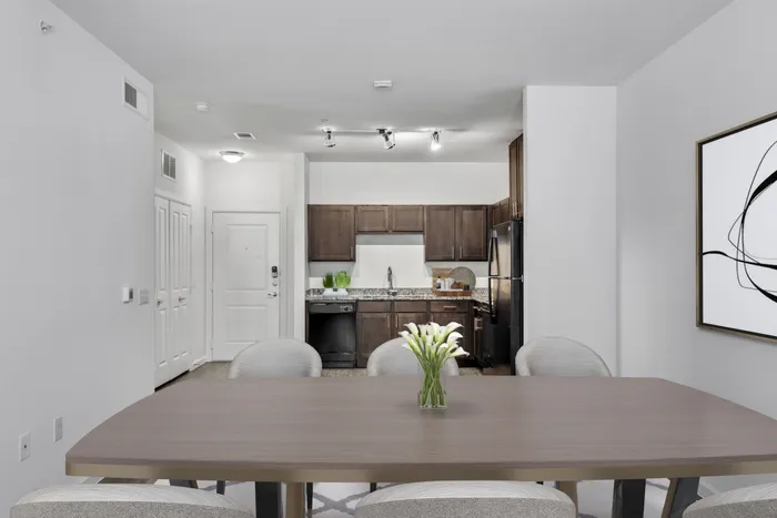 Open and spacious kitchen and living room with dark stained-wood cabinets, black stainless steel appliances, and plenty of room for furniture at Lantower Techridge