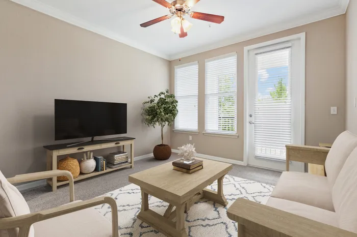 Carpeted living room with access to a private balcony, two large windows, modern, cream furniture and a TV on a wooden stand at Lantower Asturia.