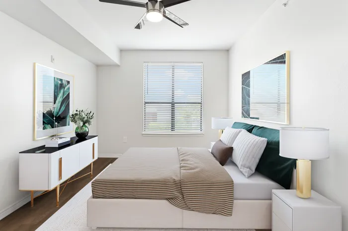 Spacious bedroom with lots of room for furniture, has a dark wood-style ceiling fan, large window for natural lighting, and hardwood flooring at Lantower Residences at the Collection