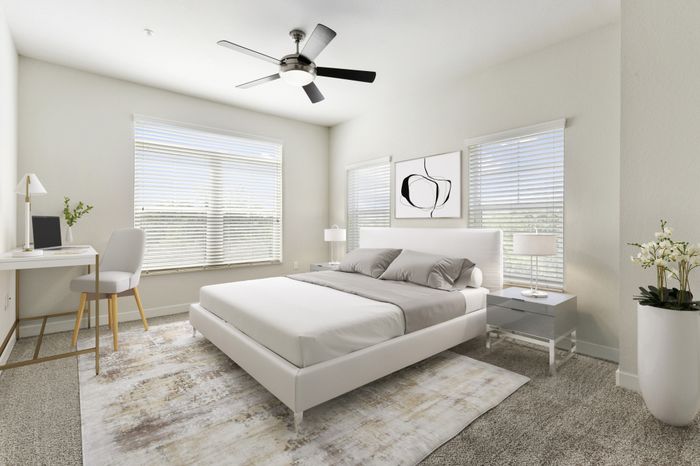 Spacious, carpeted bedroom with a ceiling fan and three large windows with ample natural light at Lantower Brandon Crossroads.