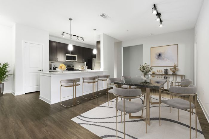 Chef-inspired kitchen with brushed nickel fixtures, 9-foot ceilings, Arctic Ice Quartz countertops and a kitchen island at Lantower Brandon Crossroads decorated with modern barstools and a bowl of fruit.