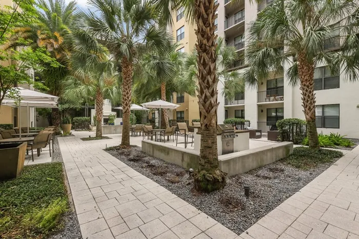 Lantower Westshore courtyard with ample seating, grills, fireplace, and palm trees.