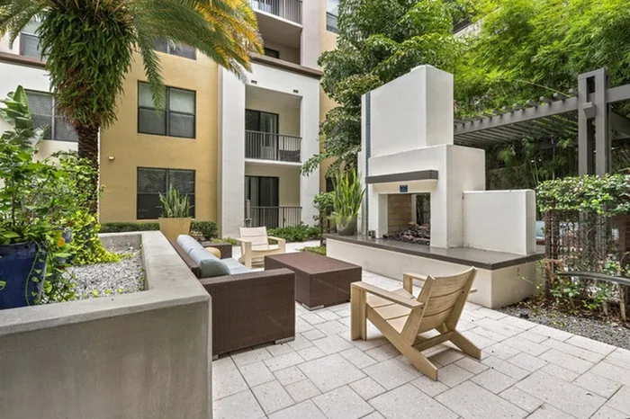 Lantower Westshore courtyard with ample seating, grills, fireplace, and palm trees.