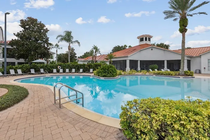 Zero-entry resort-style pool with sun deck, plenty of seating, and lush green shrubbery at Lantower Tortuga Bay.
