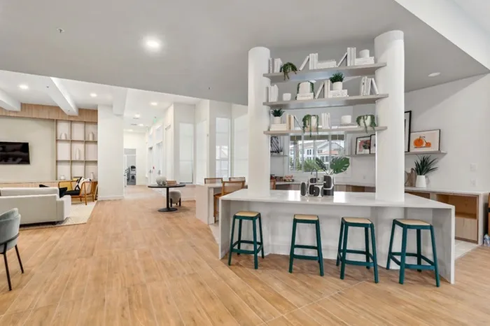 Clubhouse at Lantower Tortuga Bay with ample seating, bright lighting, wood-style floors, and flat screen television.
