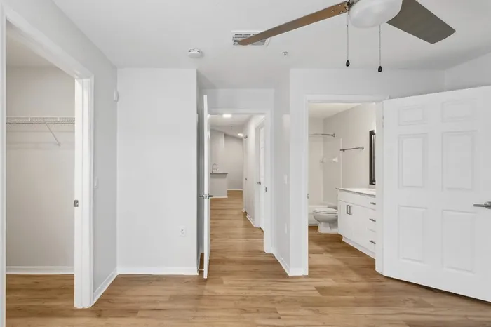 Large bedroom with ceiling fan, wood plank floors, walk-in closet, and private bathroom at Lantower Tortuga Bay.