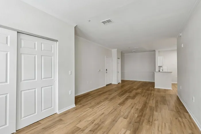 Spacious open-concept living and kitchen area with wood plant flooring and natural light provided by two windows at Lantower Tortuga Bay.