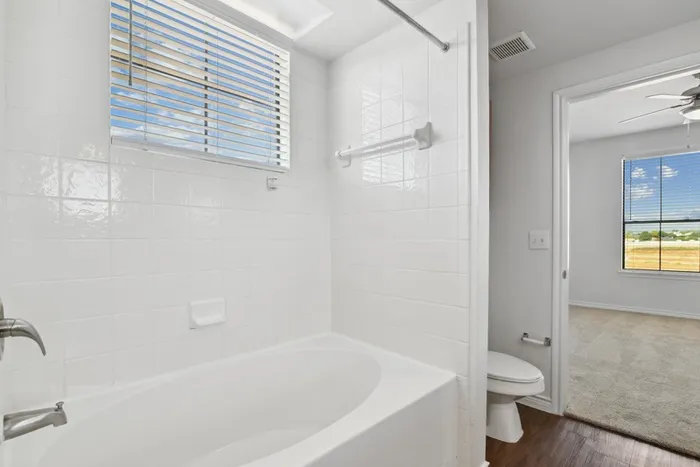 Bathroom with large garden tub with window for natural light at Residences at the Collection.