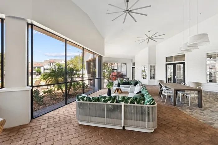 Covered and screened community patio with ample seating and ceiling fans at Tortuga Bay at Waterford Lakes.