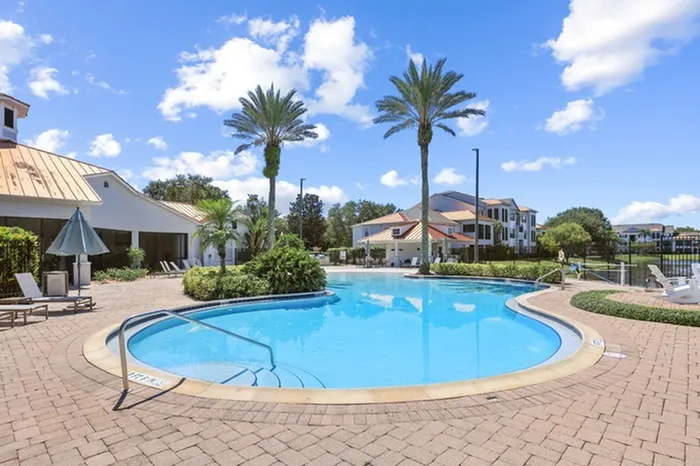 Sparkling swimming pool with plenty of seating at Tortuga Bay at Waterford Lakes.