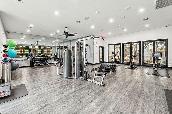 Spacious fitness center with cardio and strength training equipment.