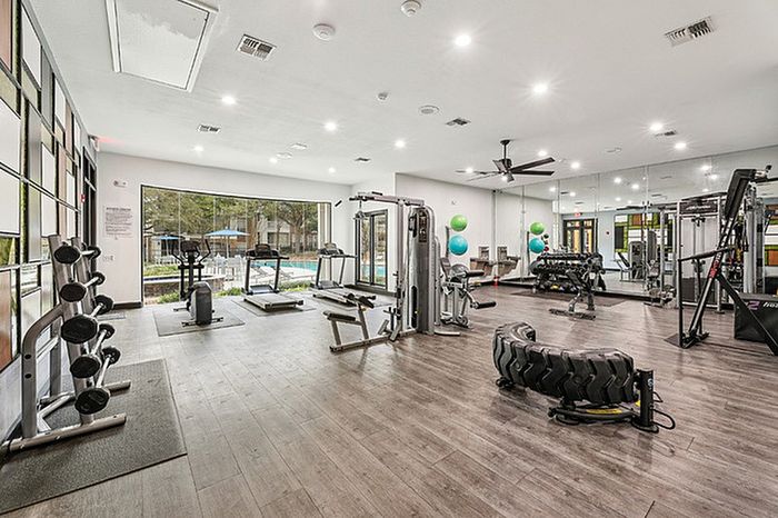 Spacious fitness center with cardio and strength training equipment.
