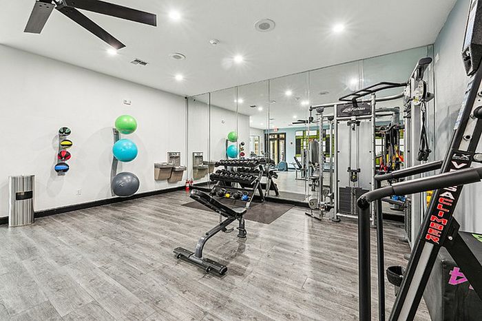 Spacious fitness center with cardio and strength training equipment.