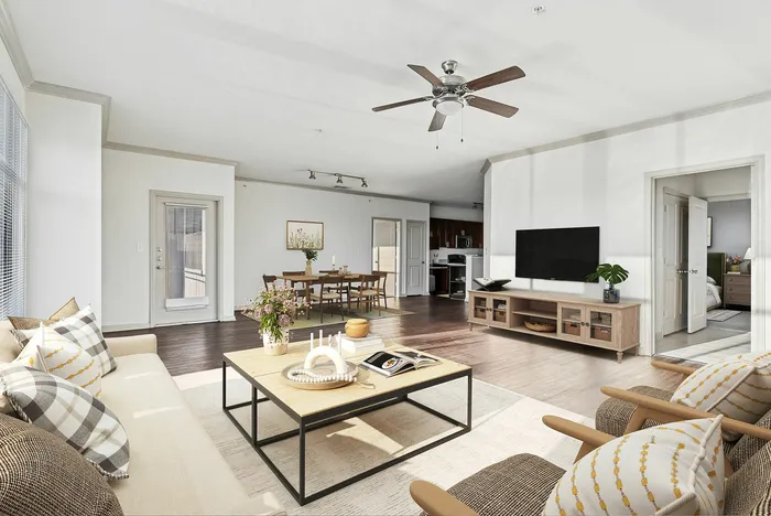 Spacious kitchen and living room with wood floors, wood cabinets, tiled kitchen floor, stainless steel appliances, ceiling fan, and access to private patio and balcony at Lantower The Cortona