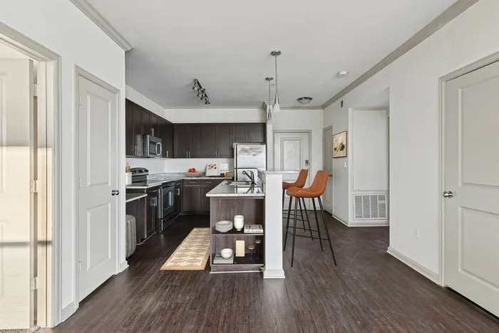 Modern kitchen with glossy countertops, stainless steel appliances, and wood cabinets at Lantower The Cortona