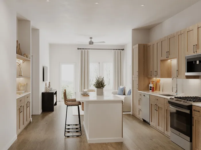 Bright and modern apartment kitchen and living area with sleek cabinetry, elegant countertop, and natural light.