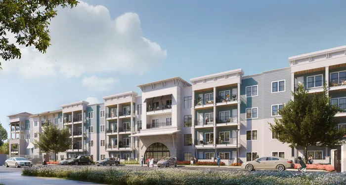 Modern apartment building with four stories, featuring spacious balconies, stylish facade, and lush landscaping under a clear blue sky.