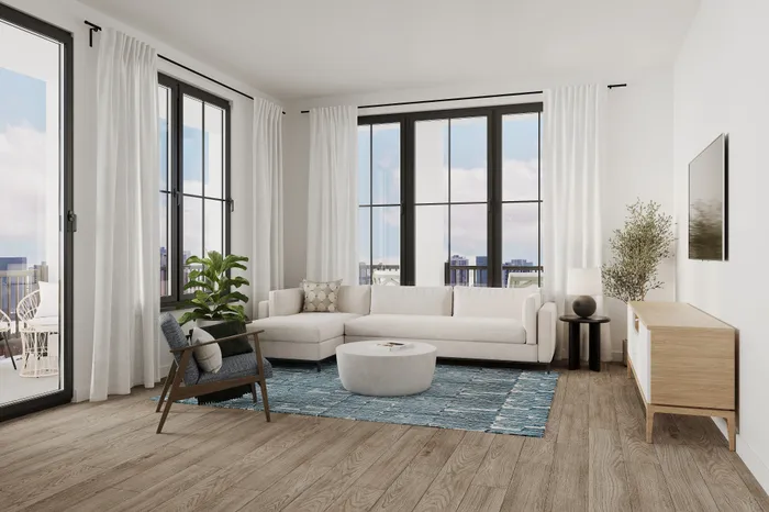 Bright and modern living room with floor-to-ceiling windows, plush sectional sofa, stylish rug, and sleek wooden furnishings.