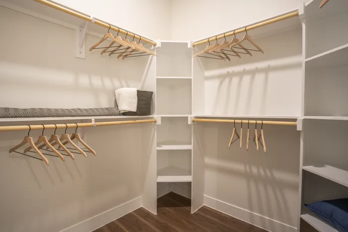 Spacious walk-in closet with wooden hangers and organized shelving, offering ample storage and elegant design.
