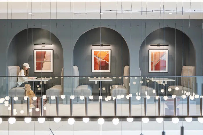 Modern lounge with elegant archways, cozy seating booths, and contemporary artwork, creating a stylish ambiance.
