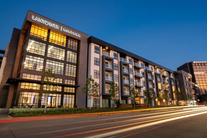 Modern apartment complex highlighted at dusk with illuminated windows and sleek architecture, capturing urban living at its finest.