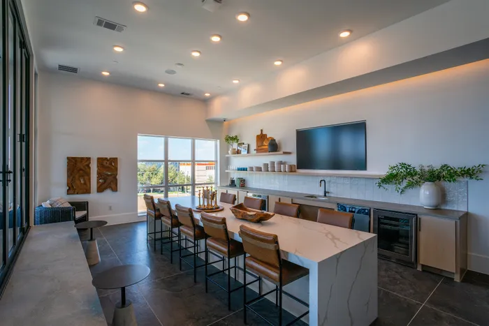 Modern open-concept kitchen and dining area featuring sleek countertops, stylish bar seating, and elegant decor with abundant natural light.