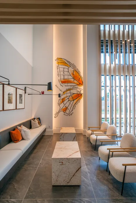 Contemporary lobby featuring artistic wall design, elegant lounge seating, and modern marble accents for a luxurious feel.