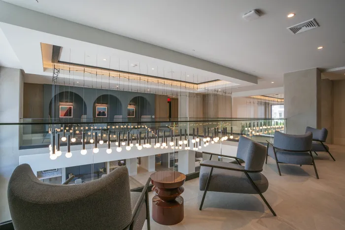 Luxurious modern living area showcasing elegant lounge chairs and contemporary pendant lighting, perfect for relaxation and social gatherings.