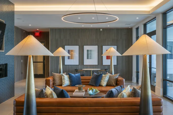 Modern elegant lounge area with stylish leather sofas, chic lamps, and contemporary artwork, offering a cozy and sophisticated atmosphere.