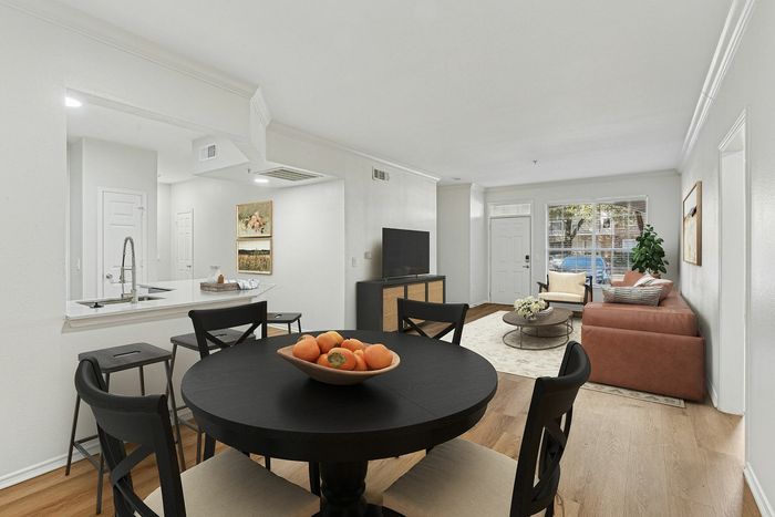 Chic, open-concept living room and kitchen with modern furnishings, bright natural light, and elegant decor.