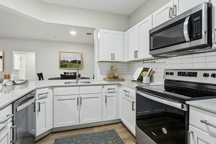 Modern kitchen with sleek white cabinetry, stainless steel appliances, and a stylish open layout perfect for entertaining.