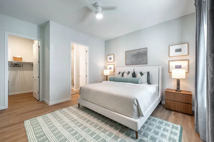 Elegant bedroom featuring a plush king-size bed, modern decor, and ample natural light.