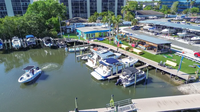 Vibrant marina view showcasing docked boats, modern amenities, lush greenery, and a charming waterside café creating a picturesque escape.